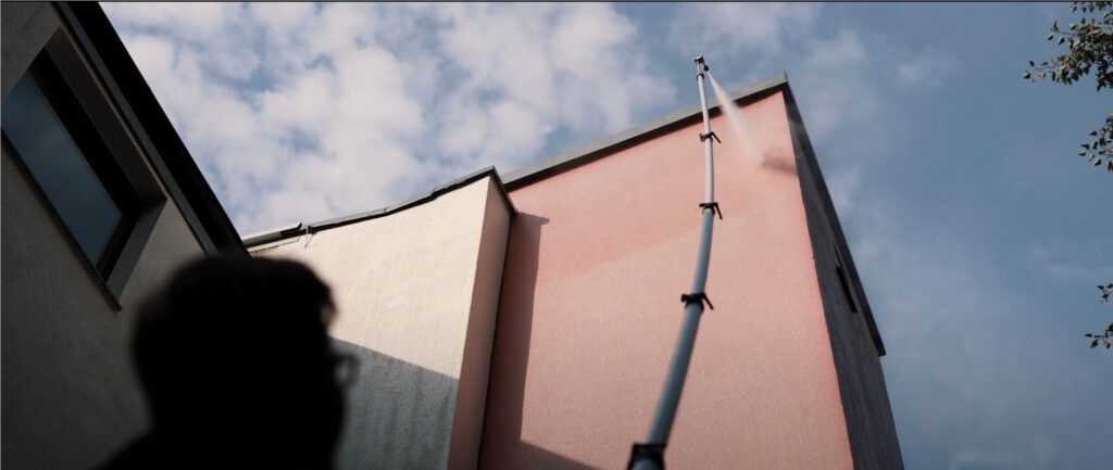 Fassadenreinigung ohne Gerüst mit Teleskoplanze an mehrstöckigem Gebäude.