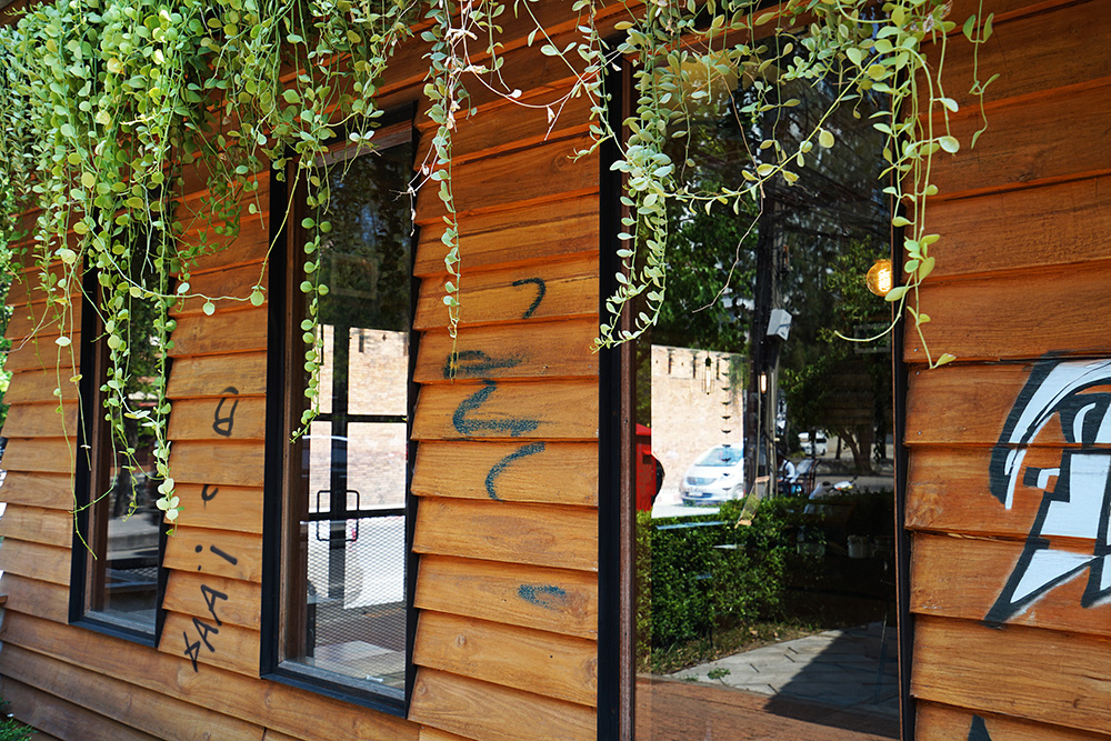 Holzfassade mit schwarzem Graffiti.