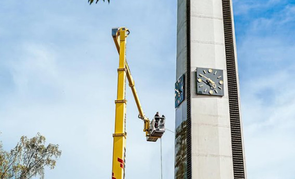 Fassadenreinigung mit Hubsteiger an Hochfassade Fassadenreinigung mit Hubsteiger an einem hohen Gebäude mit Arbeitsbühne in großer Höhe