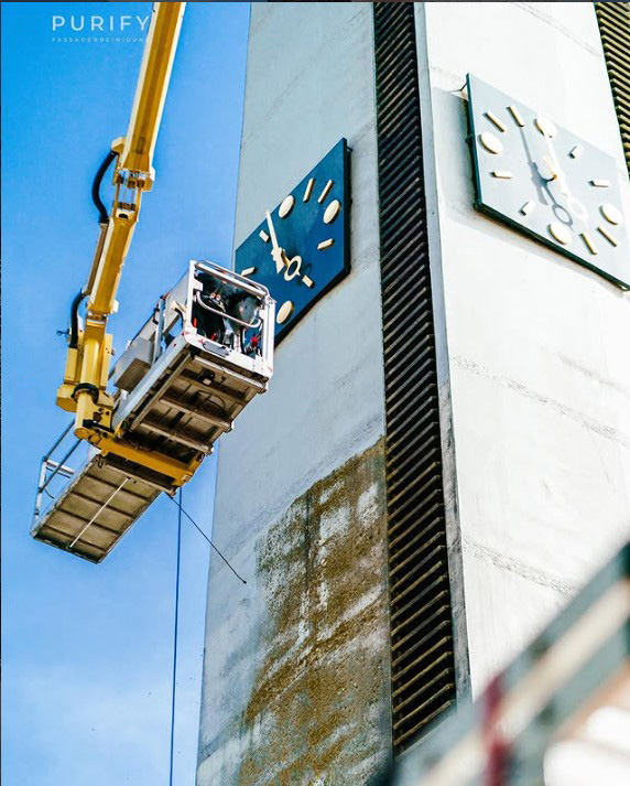 Fassadenreinigung mit Hubsteiger an einer Gebäudefassade mit sichtbaren Verschmutzungen