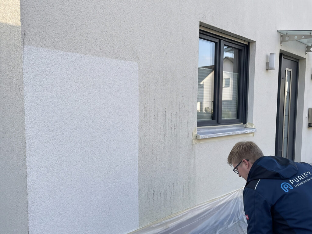Was gehört zur Fassadenreinigung? Probefläche an einer Putzfassade, geschützte Fensterbank und Vorbereitung der Umgebung durch einen Fachbetrieb.