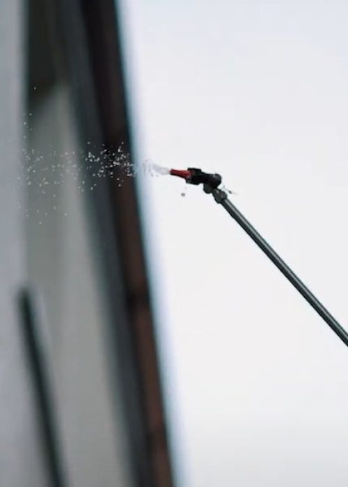 Eine Putzfassade wird in Göppingen mit einer Teleskoplanze unter kontrolliertem Wasserdruck gereinigt.
