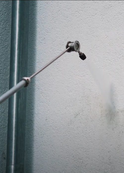 Eine verschmutzte Putzfassade wird in Göppingen mit einer Teleskoplanze gereinigt – der Wasserstrahl trifft punktgenau auf die betroffene Stelle.