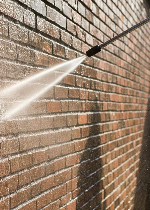 Eine Klinkerfassade wird mit einer Niederdrucklanze gereinigt – Fassadenreinigung in Pforzheim mit wasserbasierter, schonender Technik.